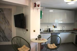 a kitchen with two chairs and a table and a sink at Casa Nido in Ríogordo