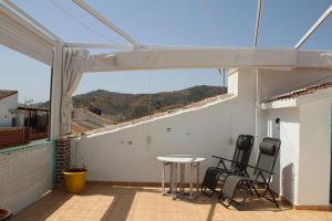 a patio with a table and chairs on a roof at Casa Nido in Ríogordo