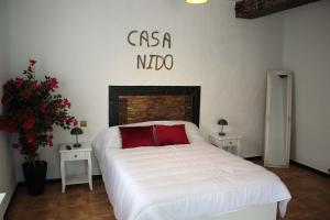 a bedroom with a white bed with a red pillow at Casa Nido in Ríogordo