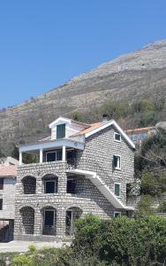 a stone house with a hill in the background at Amore apartments in Budva