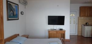 a bedroom with a bed and a flat screen tv at Amore apartments in Budva +4 photos