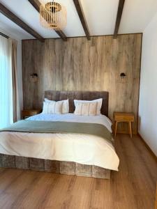 a bedroom with a large bed with a wooden wall at SevenHeaven in Mărişel