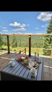 a picnic table with food and drinks on a deck at SevenHeaven in Mărişel