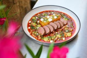 a plate of food with sausage and vegetables on a table at Imola Udvarház Dessert Hotel in Eger