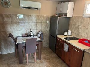 a small kitchen with a table and a refrigerator at Lakeside oasis home Karuc in Karuč