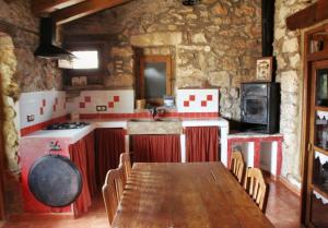 a kitchen with a long wooden table in a room at Casa rural Más La Torreta con vistas al Pla de Vistabella cerca del Peñagolosa Pet Friendly niños gratis in Vistabella del Maestrazgo