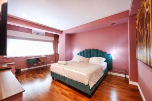 a bedroom with a large bed with a green headboard at Tao chambre in Taormina