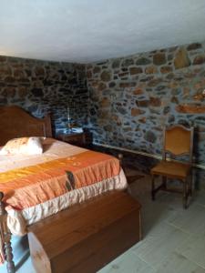 a bedroom with a bed and a chair at Casinha Meixedo in Bragança +7 photos