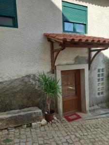 a house with a door and a plant in front of it at Casinha Meixedo in Bragança