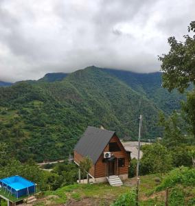 a house on a hill with mountains in the background at Keda Horizon Cottage in Koromkhet'i +3 photos