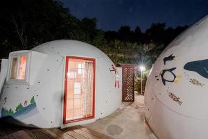 two round houses with a door and a window at Jeongsun Hayandom Pension in Jeongseon