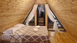 a bed in a wooden room with a window at Keda Horizon Cottage in Koromkhet'i