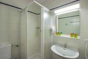 a white bathroom with a sink and a shower at Hotel garni Zwickau-Mosel in Mülsen +46 photos