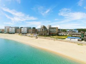 a view of a beach with buildings in the background at Goseong Romiet Pension in Goseong +20 photos
