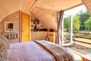 a bedroom with a bed and a large window at Finest Retreats - Idris Pod in St Asaph