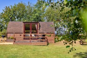 a large wooden cabin in a field of grass at Finest Retreats - Idris Pod in St Asaph