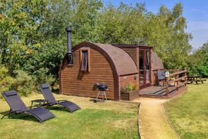 a small cabin with two chairs and a grill at Finest Retreats - Idris Pod in St Asaph +8 photos