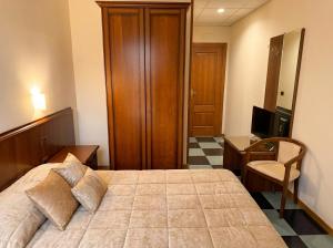 a bedroom with a bed and a desk and a television at Locanda Panorama Picerno in Picerno