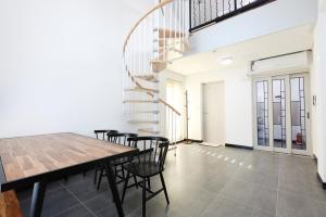 a dining room with a wooden table and chairs at Samcheok santiago pension in Samcheok