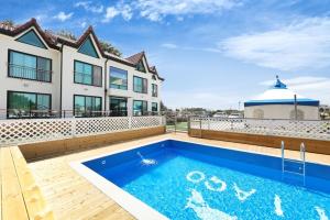 a house with a swimming pool in front of a house at Samcheok santiago pension in Samcheok