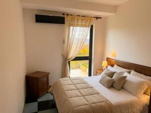a bedroom with a bed and a large window at Locanda Panorama Picerno in Picerno