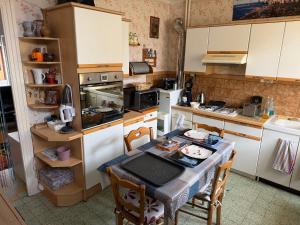 a kitchen with a table and a table and chairs at chambre d hotes chez josiane in Mayenne