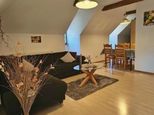 a living room with a black couch and a table at Ferienhof Aiginger in Grafenau