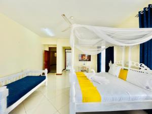 a bedroom with a white bed with a canopy at Elna's Nyali - Work & Unwind - Pool, Sea Views, AC & Fast Wi-Fi in Mombasa