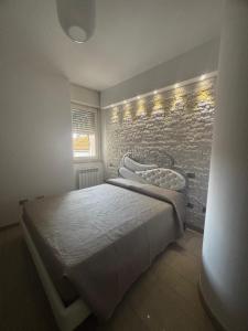 a bedroom with a bed and a brick wall at Carducci Sunrise in Tortoreto Lido