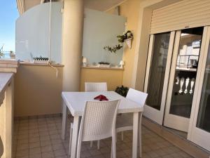 a white table and chairs on a balcony at Carducci Sunrise in Tortoreto Lido