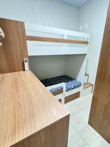 an empty bunk bed with a bench in a room at Área de Lazer in Limeira