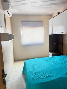 a bedroom with a blue bed and a window at Área de Lazer in Limeira