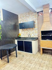 a kitchen with a counter and a sink and a table at Área de Lazer in Limeira