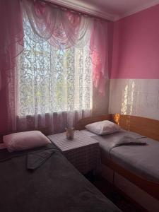 a room with two beds and a window with a cat on a table at Sea Panorama in Karolino-Buhaz