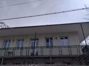 a building with a balcony in front of it at Maias guest house in Kazbegi