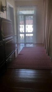 a living room with a large window and a red rug at Maias guest house in Kazbegi