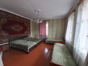 a bedroom with two beds and a chandelier at Maias guest house in Kazbegi