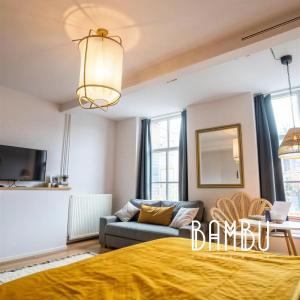 a living room with a bed and a couch at Bambu Kitchen & Bar - Hotel Restaurant in Haarlem