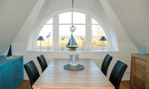 a dining room with a wooden table and a window at Am Kranichland in Wieck +8 photos
