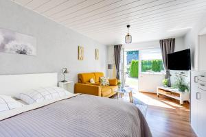 a bedroom with a bed and a living room at Sonnenblumenhaus 01 in Prerow