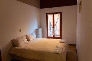 a small bedroom with a bed with a window at Debre Mariam Guest House in Bologna