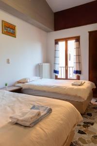 two beds in a room with a window at Debre Mariam Guest House in Bologna