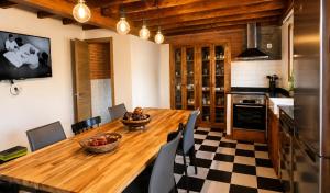 a kitchen and dining room with a wooden table at Casa Rural La Eugenia · Picos de Europa · Cabrales in Puertas +17 photos