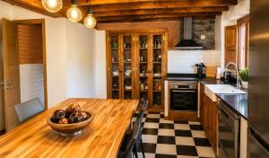 a kitchen with a wooden table with a bowl of fruit at Casa Rural La Eugenia · Picos de Europa · Cabrales in Puertas