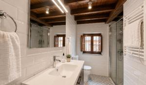 a white bathroom with a sink and a shower at Casa Rural La Eugenia · Picos de Europa · Cabrales in Puertas