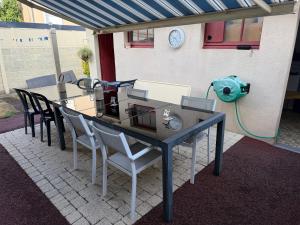 a table with chairs and a machine on a patio at chambre d hotes chez josiane in Mayenne