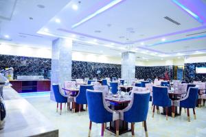 a restaurant with blue chairs and tables in a room at Exclusive Serene Hotel Abuja in Abuja +20 photos