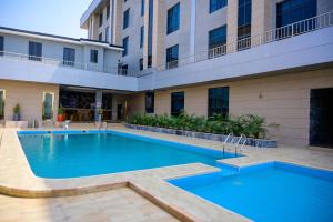 a large swimming pool in front of a building at Exclusive Serene Hotel Abuja in Abuja