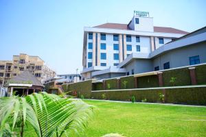 a large building with a lawn in front of a building at Exclusive Serene Hotel Abuja in Abuja