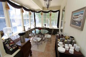 sala de estar con mesa, sillas y ventanas en The Rendell Shea Manor en San Juan de Terranova